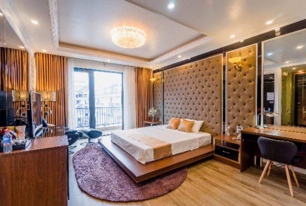 - une grande chambre avec un lit et un bureau dans l'établissement BBQ HOSTEL, à Hạ Long
