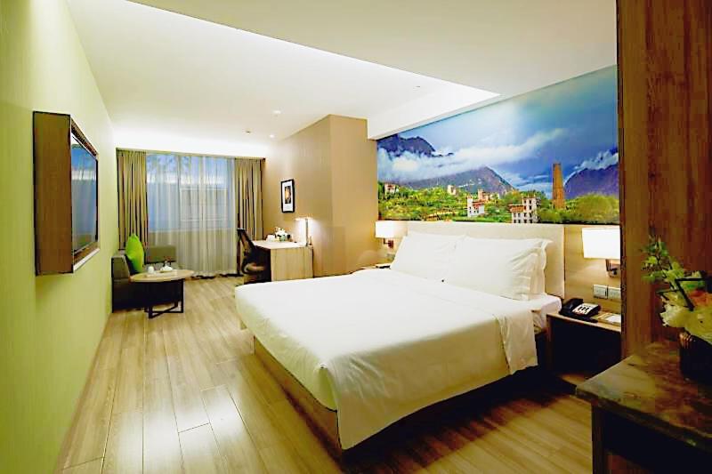 a bedroom with a large white bed and a desk at Atour Hotel Chengdu Wuhou Temple in Chengdu