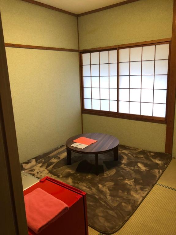 a corner of a room with a table and a window at Oyado Zen in Kusatsu