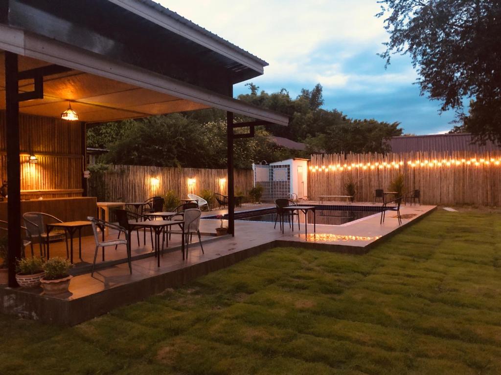 a patio with a table and chairs and a fence at Serene Resort in Pai