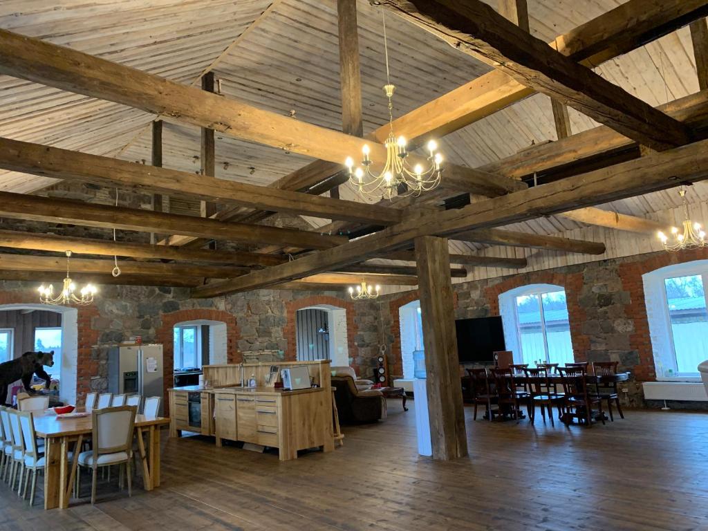 a large room with wooden ceilings and tables and chairs at Nooruse puhkemaja in Uhtna