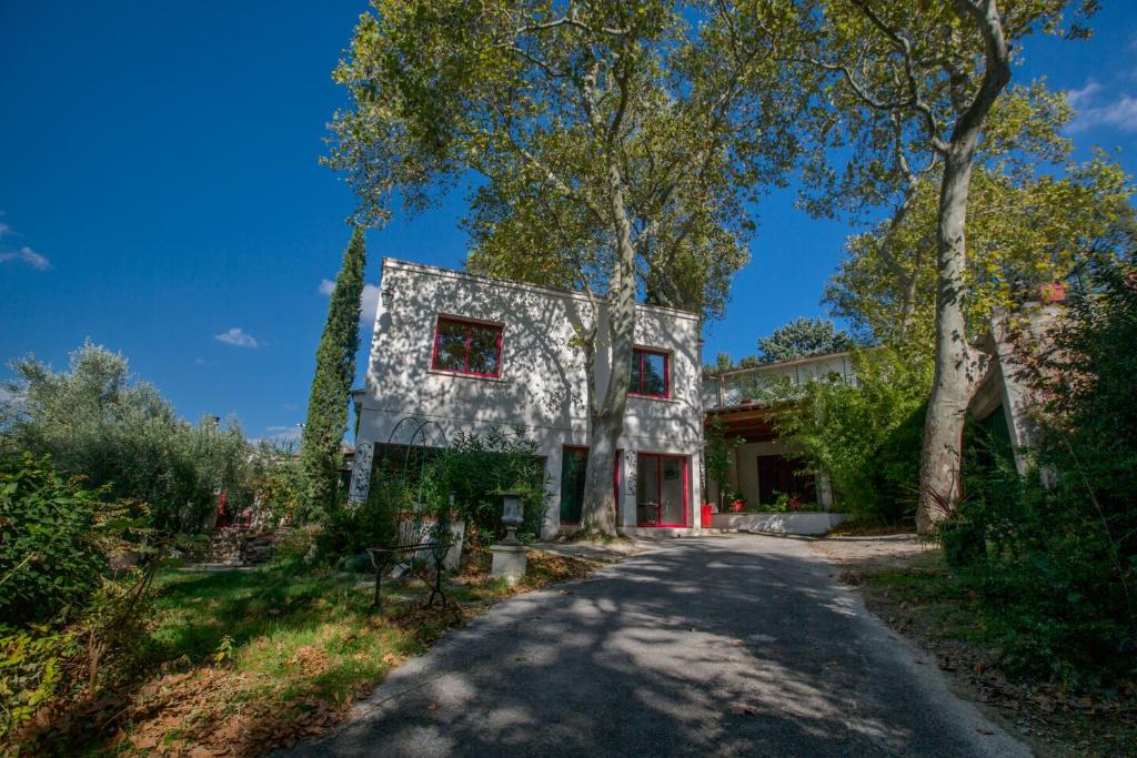 a gray house with red windows on a road at Duché d'Uzès Villa Celina Avenue des Cévennes in Uzès