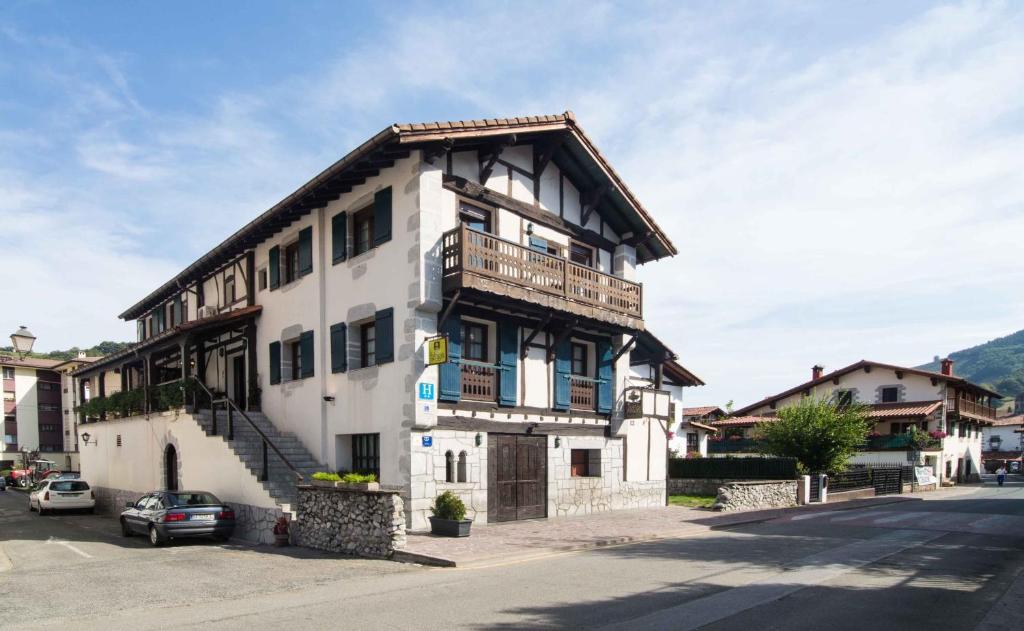 a white building with a gambrel roof at Hotel SPA Atxaspi in Lesaka