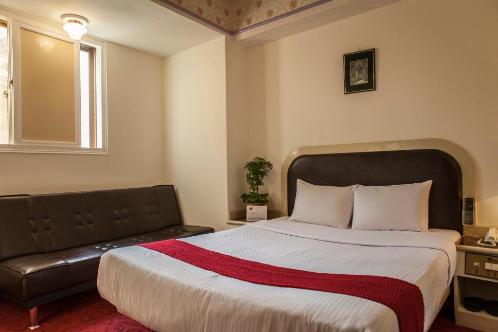 una camera con un grande letto e un divano di Good Hotel a Fengyuan