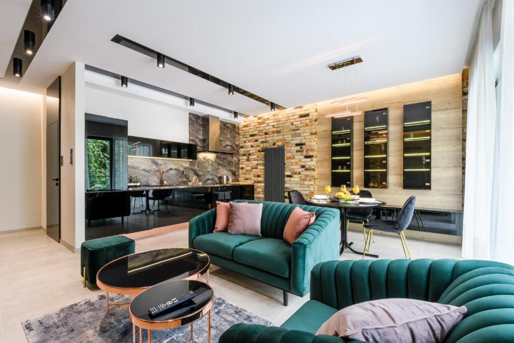 un soggiorno con divano verde e tavolo di ZLOTA Luxury Apartments a Varsavia