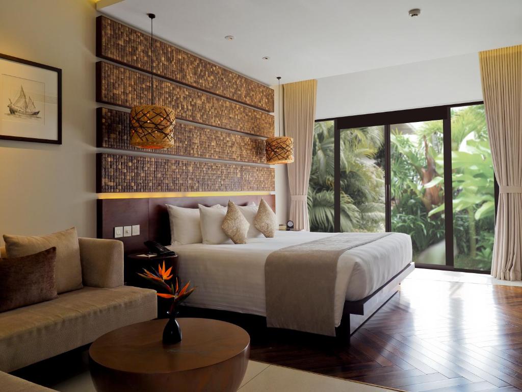 1 dormitorio con 1 cama y 1 sofá en Salinda Resort Phu Quoc - Sparkling Wine Breakfast en Phu Quoc