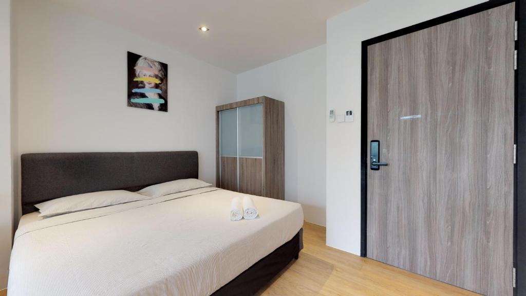 a bedroom with a large bed and a wooden door at International Service Apartments at Raeburn Park in Singapore