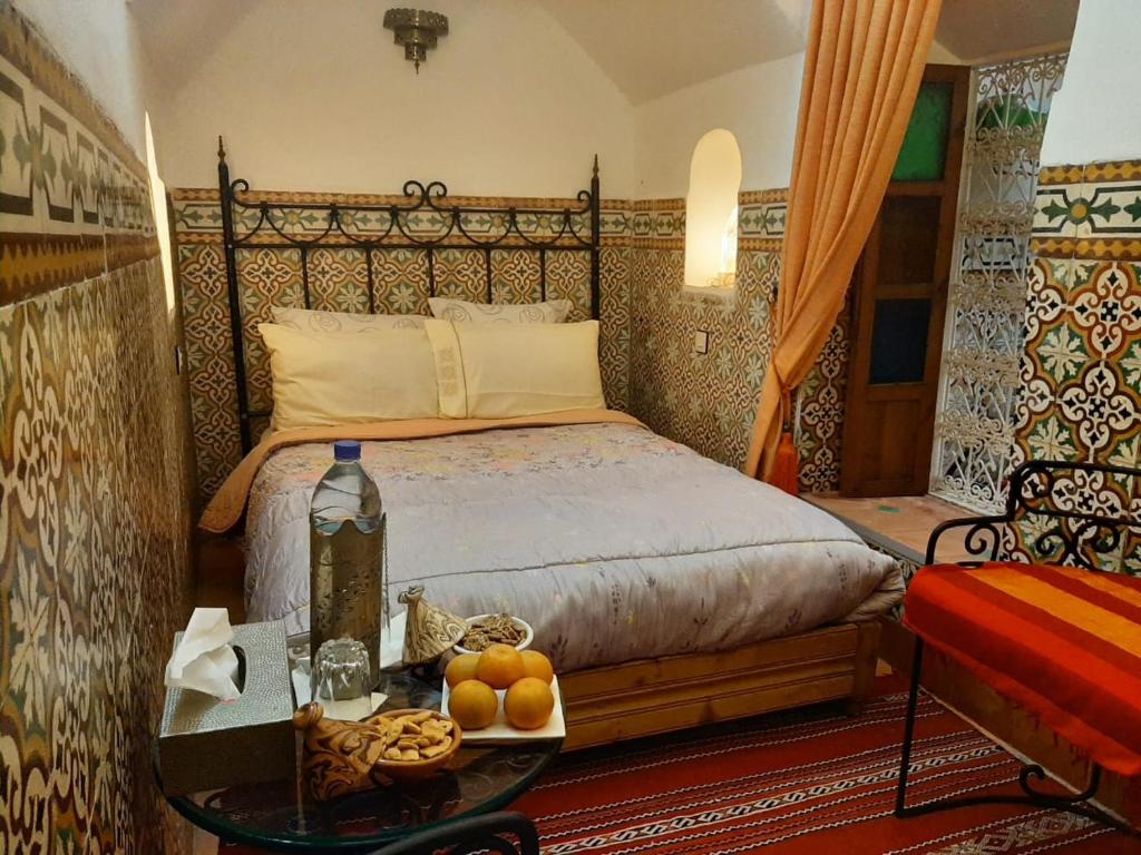 a bedroom with a bed and a table with a tray of fruit at RIAD Redous in Marrakesh