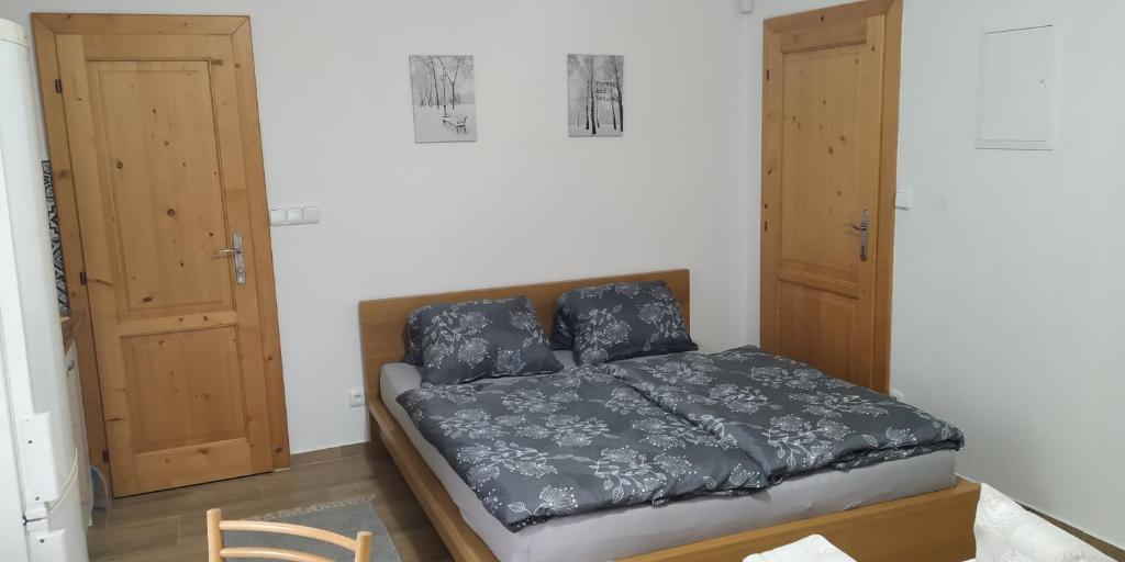 1 dormitorio con 1 cama y 2 armarios de madera en Ubytování Na Vyhlídce 143 en Benátky nad Jizerou