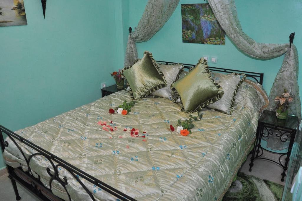 Una cama con flores en un dormitorio en Riad Dar Mesouda en Tánger
