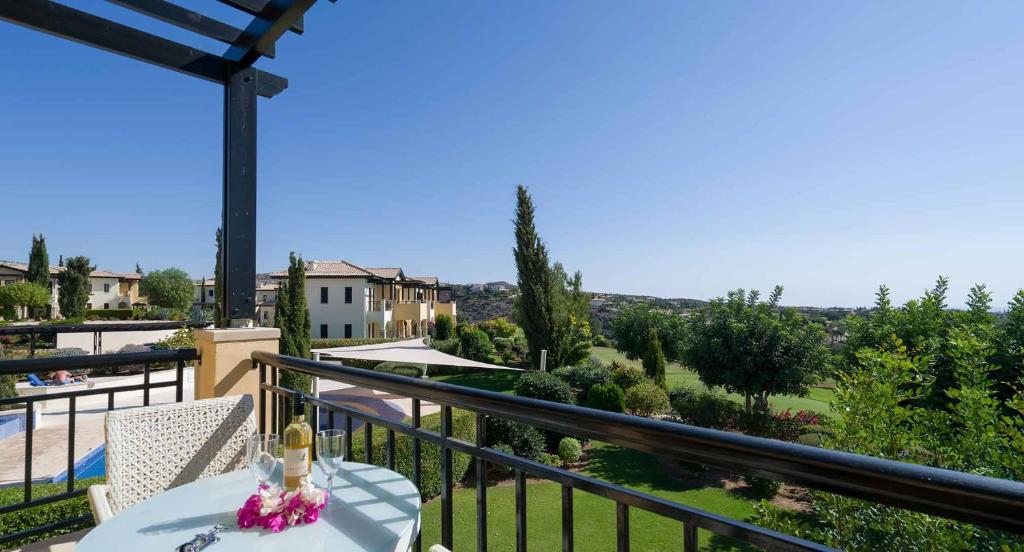 balcón con mesa y vistas al jardín en 1 bedroom Apartment Nesoi with sea and golf views, Aphrodite Hills Resort en Kouklia