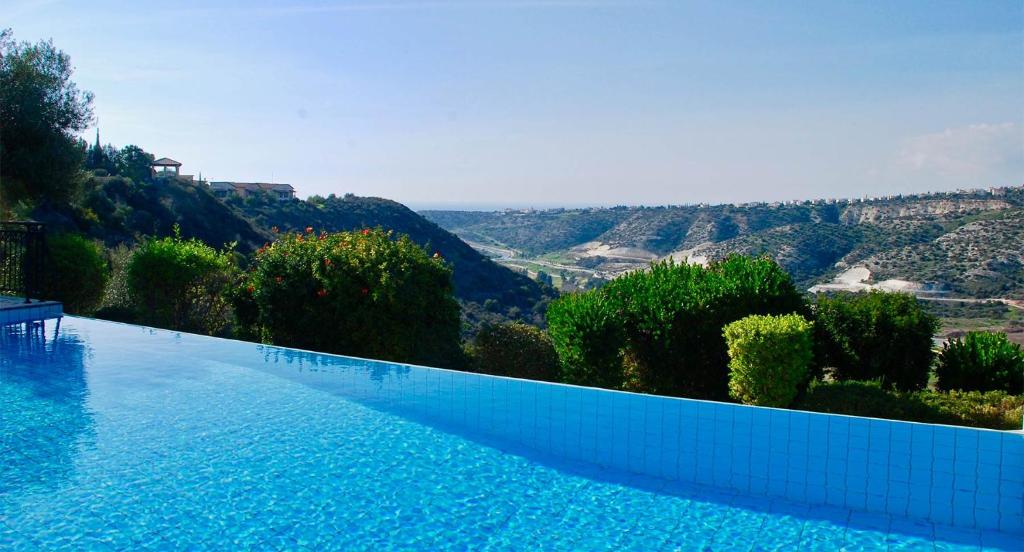 a large swimming pool with a view of the mountains at 4 bedroom Villa Kourion with private pool, Aphrodite Hills Resort in Kouklia