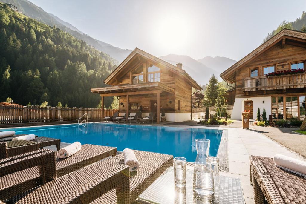 ein Resort mit Pool und Haus in der Unterkunft Wellnesshüttendorf Wiese in Sankt Leonhard im Pitztal