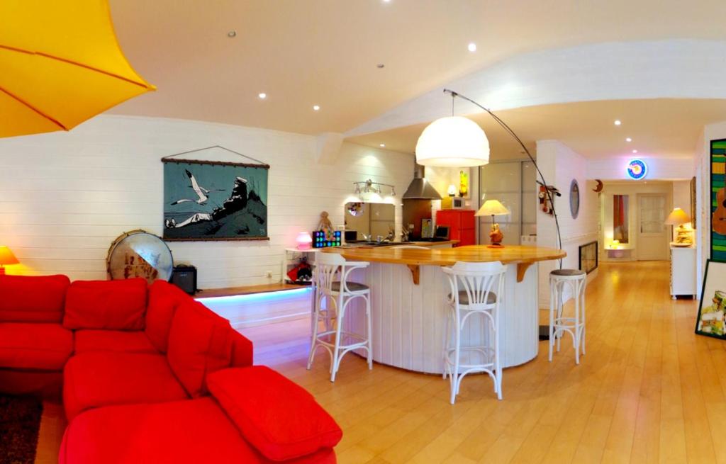 a living room with a red couch and a kitchen at Maison de 3 chambres avec jardin clos et wifi a Montlucon in Montluçon