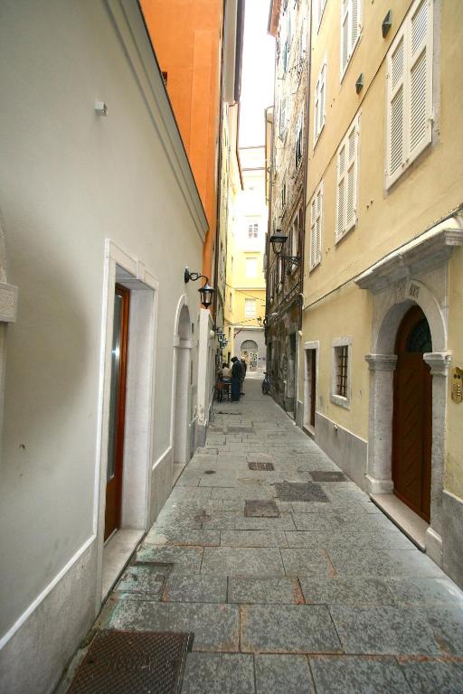 an empty alley in an alley way between buildings at Piazza Grande City Residence in Trieste