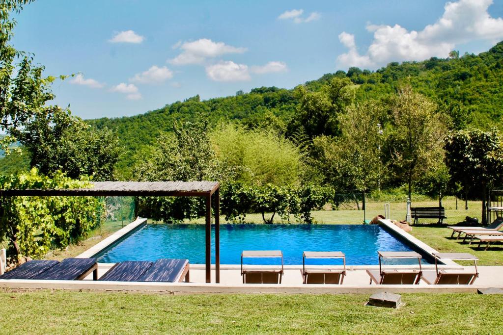 einen Pool mit zwei Stühlen und einem Pavillon in der Unterkunft Tuttaterra in Serra San Quirico