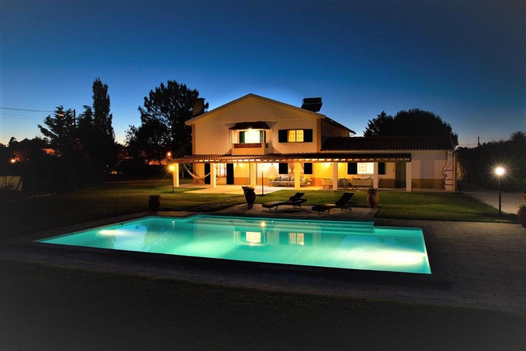 a house with a swimming pool at night at Quinta Turki Malika in Óbidos