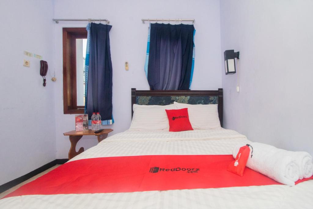 Postel nebo postele na pokoji v ubytování RedDoorz near Pantai Boom