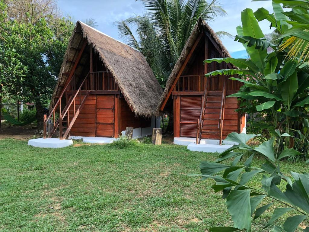 a house with a thatched roof and a yard at Lazy Bones in Koh Rong Sanloem
