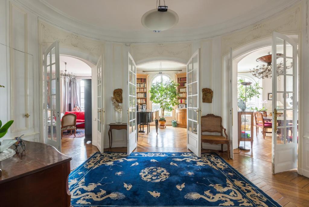 - un salon avec un tapis bleu au sol dans l'établissement Veeve - Haussmann Beauty in the 6th, à Paris