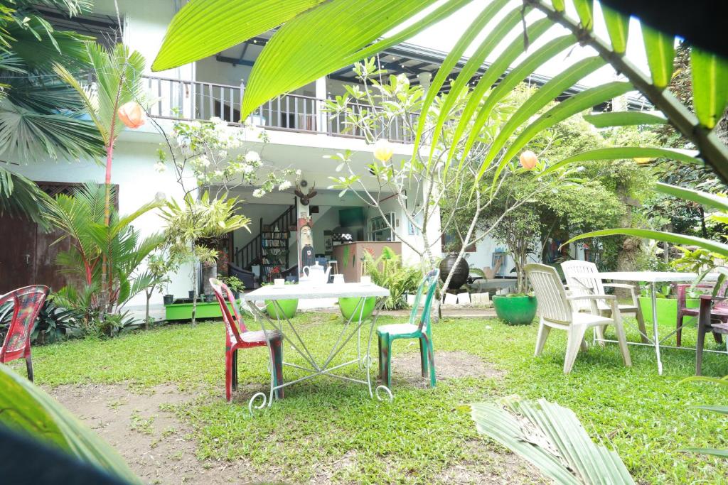 - un ensemble de chaises et d'une table dans un jardin dans l'établissement Pearl Villa Rooms and Hostel, à Unawatuna