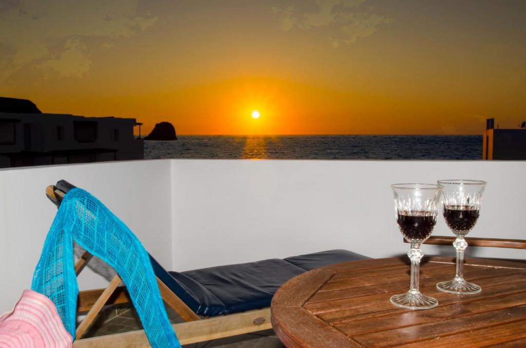 dos copas de vino en una mesa con vistas al océano en Villa Sosanna en Pollonia