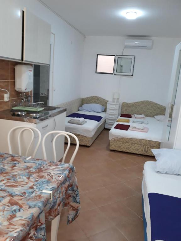 een hotelkamer met 2 bedden en een tafel bij Apartments Jovanic with 2 bedrooms in Sutomore