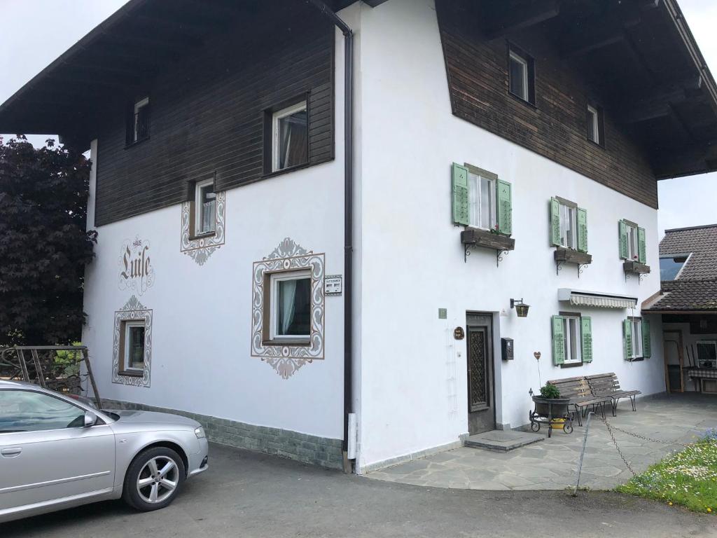 a white building with a car parked in front of it at Haus Luise in Westendorf