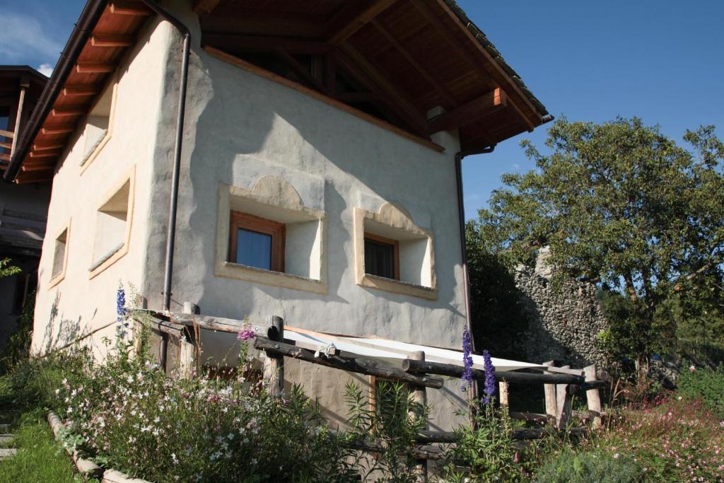 a house with two windows on the side of it at La casa di paglia B&B in Verrayes