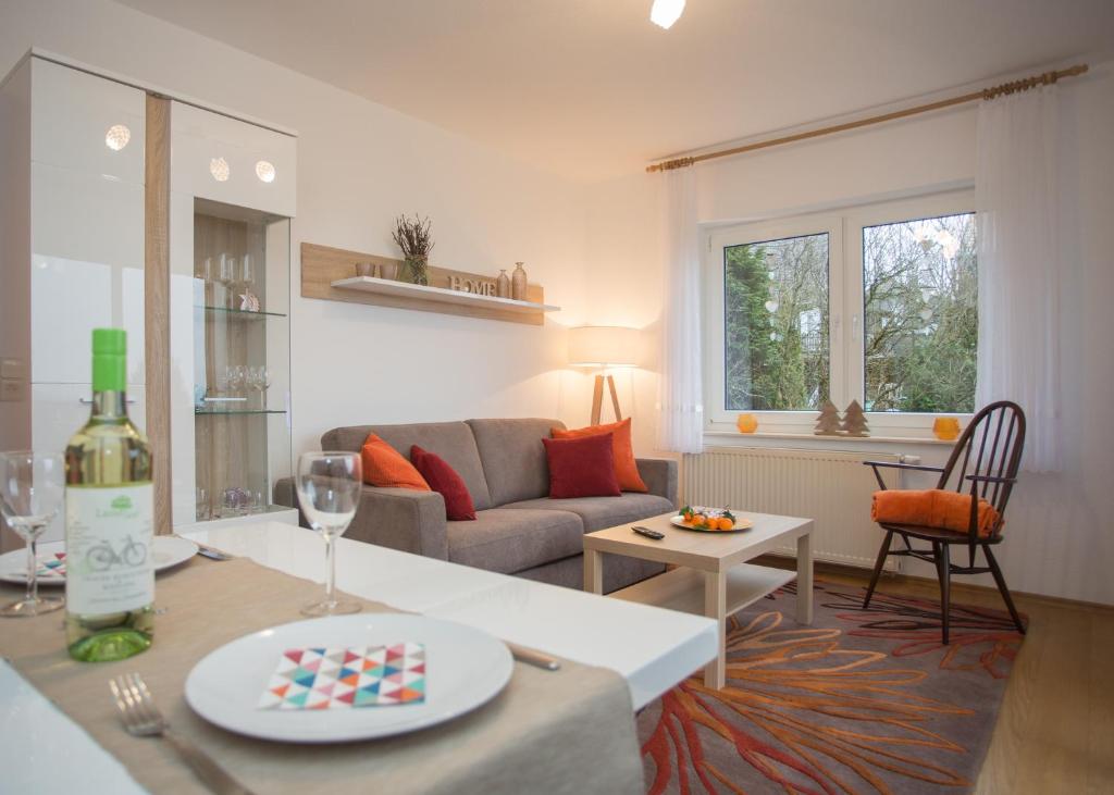 a living room with a couch and a table with a bottle of wine at Ferienwohnung Little Home in Winterberg-Neuastenberg in Winterberg