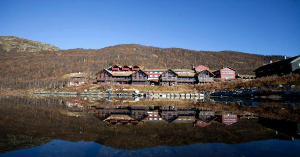 um reflexo de um grupo de casas numa massa de água em Vågslidtun Hotel em Vågsli