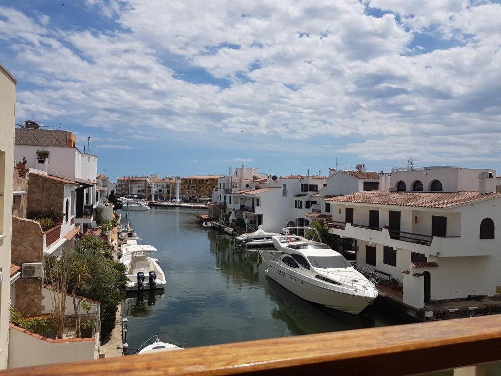 a group of boats docked in a canal with buildings at Magnífico apartamento junto al canal principal. in Empuriabrava