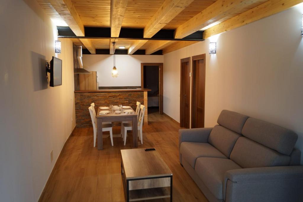 - un salon avec un canapé et une table dans l'établissement Puente viejo de Buitrago casa Fresno, à Buitrago del Lozoya
