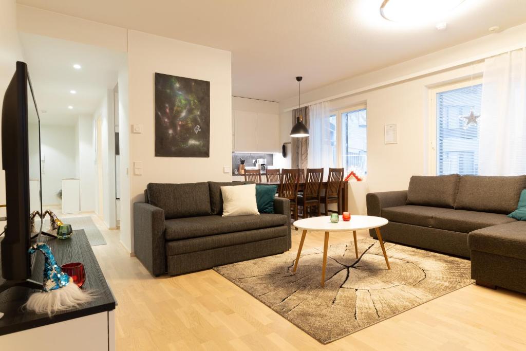 a living room with two couches and a table at Apartment Loimu C75 in Rovaniemi