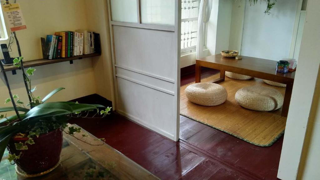 una stanza con un tavolo e due sgabelli sul pavimento di ZYIN Homestay a Kaohsiung