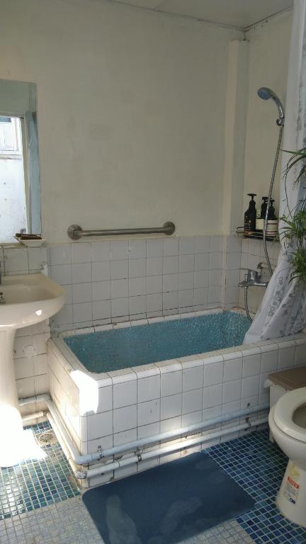 un bagno con vasca, lavandino e WC di ZYIN Homestay a Kaohsiung