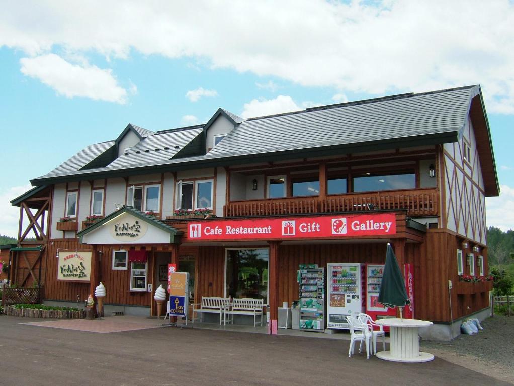 ein Gebäude mit einem Laden mit einem Tisch davor in der Unterkunft Farm Inn Tsurui in Tsurui