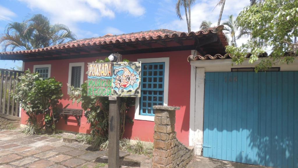 una casa roja y azul con un garaje azul en Pousada Maria da Toca, en Rio das Ostras