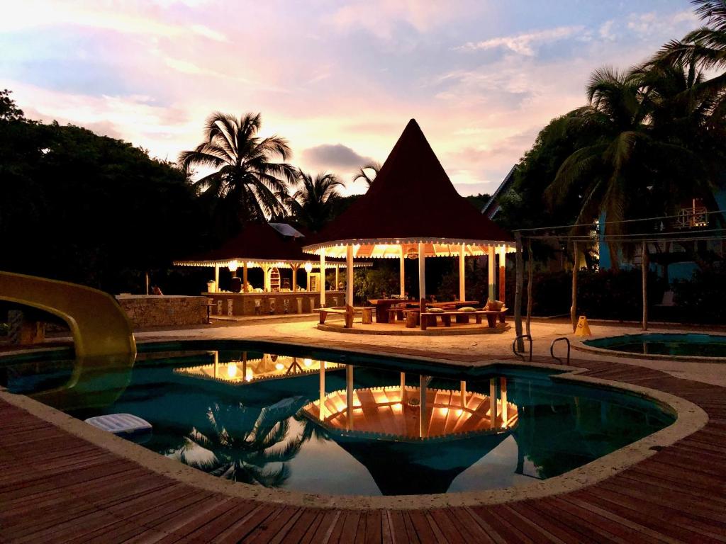 a pool at a resort with a restaurant in the background at Secreto Hostel in Isla Grande