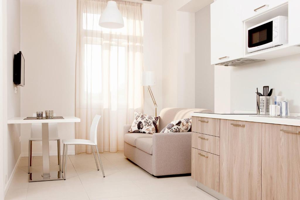 a kitchen and living room with a couch and a table at Palazzo Talenti 1907 in Trieste