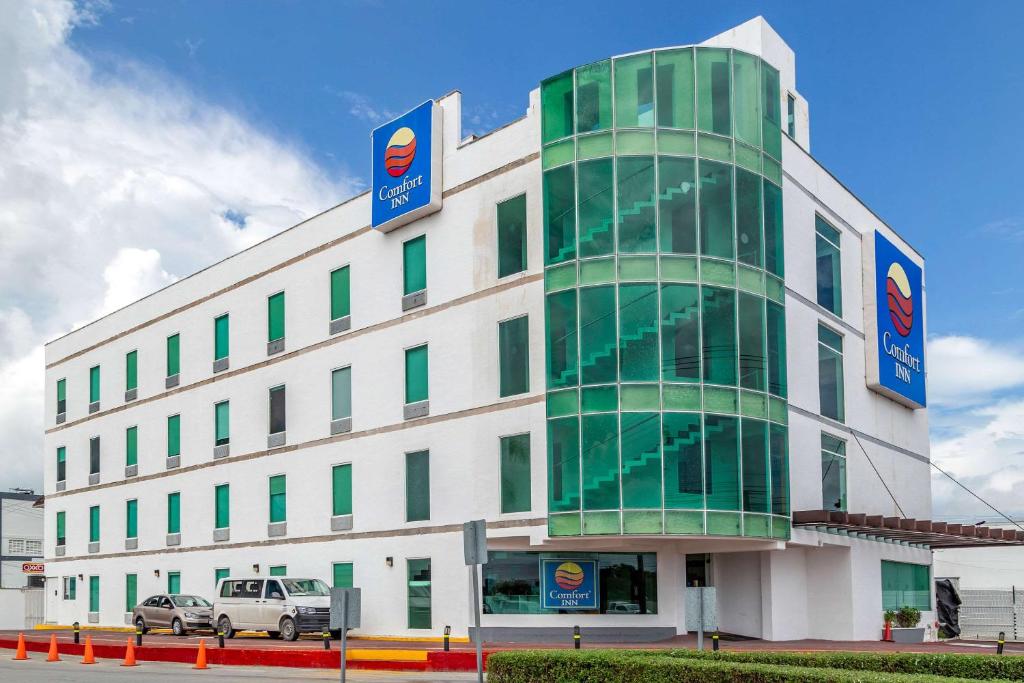 a large building with a clock on the front of it at Comfort Inn Cancún Aeropuerto in Cancún