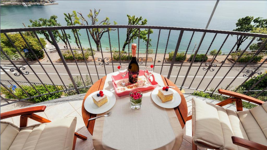 a table with two slices of cake and a bottle of wine at Apartment Villa Lidija in Lovran