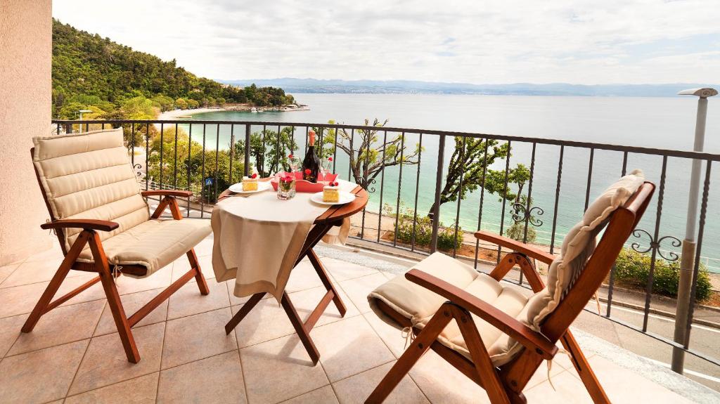 a balcony with a table and chairs and a view of the water at Apartment Villa Lidija in Lovran