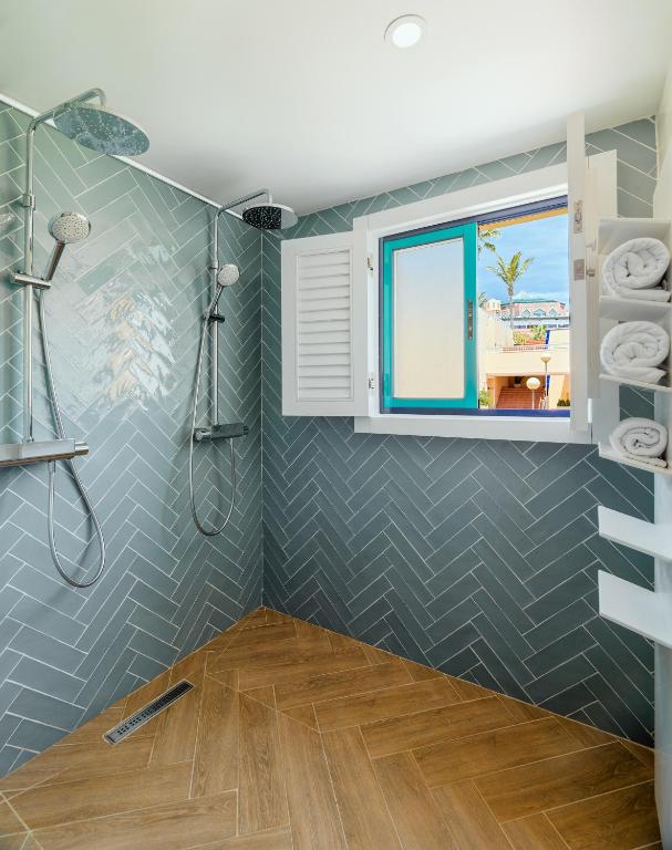 a bathroom with a shower and a window at H10 Playa Esmeralda - Adults Only in Costa Calma
