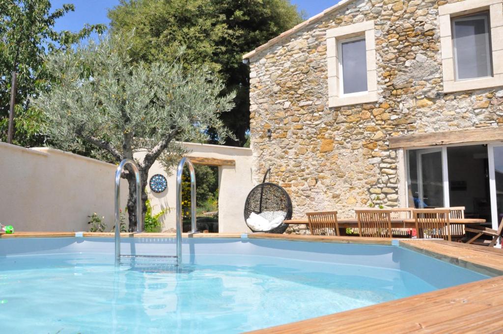 a swimming pool in front of a house at Un petit coin de paradis in Le Péage