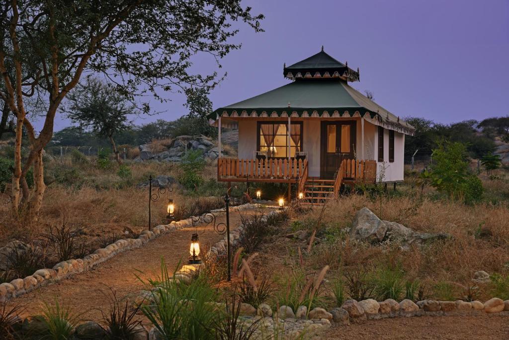 un cenador en un jardín por la noche con luces en Jawai Leopard Safari Lodge, en Bera