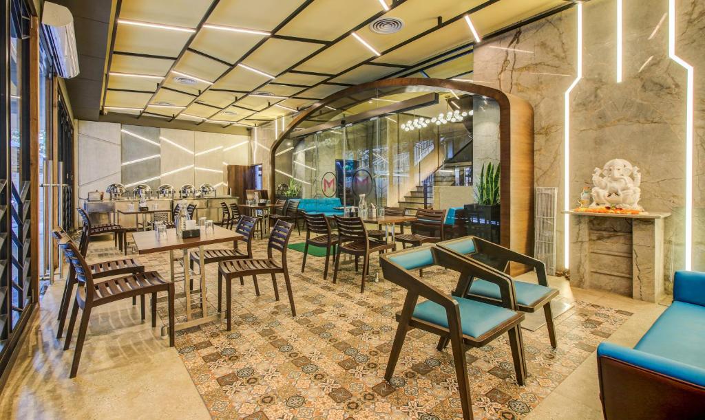 a restaurant with chairs and tables in a room at Hotel Metropole Inn in Mumbai