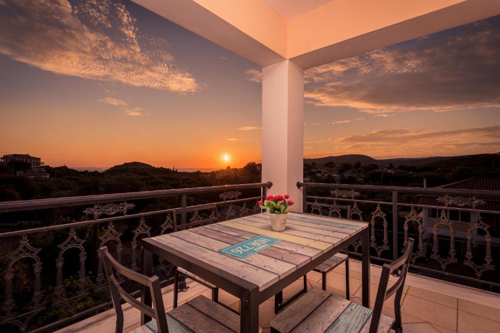 una mesa y sillas en un balcón con puesta de sol en Sunset House, en Kerion