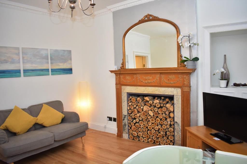 a living room with a fireplace and a mirror at Rose Street - Watchmakers Apartment in Edinburgh