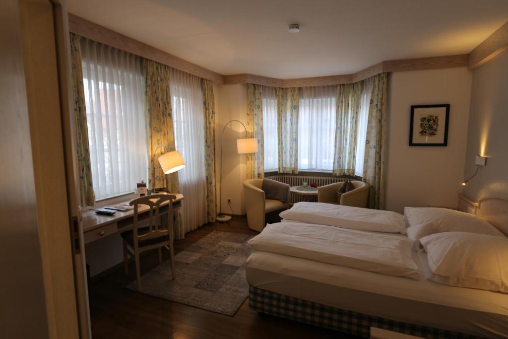 ein Hotelzimmer mit einem Bett und einem Schreibtisch in der Unterkunft Hotel-Restaurant & Metzgerei Rößle in Dettingen an der Erms
